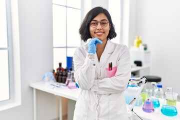 Canvas Print - Young latin woman wearing scientist uniform standing at laboratory