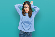 Young Beautiful Woman Wearing Casual Clothes And Glasses Doing Bunny Ears Gesture With Hands Palms Looking Cynical And Skeptical. Easter Rabbit Concept.