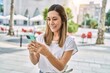 © Krakenimages.com - Young hispanic woman smiling confident using smartphone at street