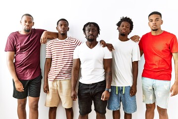 Poster - Young african group of friends standing together over isolated background relaxed with serious expression on face. simple and natural looking at the camera.