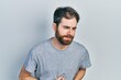 © Krakenimages.com - Caucasian man with beard wearing casual grey t shirt with hand on stomach because indigestion, painful illness feeling unwell. ache concept.
