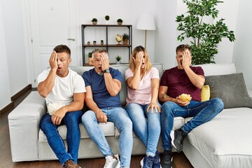 Poster - Group of middle age people sitting on the sofa at home yawning tired covering half face, eye and mouth with hand. face hurts in pain.