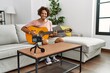 © Krakenimages.com - Young hispanic man recording with camera playing classical guitar at home.