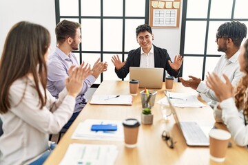 Wall Mural - Group of business workers smiling and clapping to partner at the office.