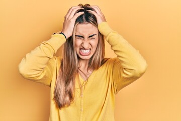 Poster - Beautiful hispanic woman wearing casual yellow sweater suffering from headache desperate and stressed because pain and migraine. hands on head.