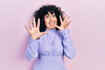 Poster - Young middle east woman wearing casual clothes afraid and terrified with fear expression stop gesture with hands, shouting in shock. panic concept.