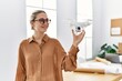 Young blonde woman smiling confident holding drone at architect studio