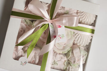 Wall Mural - Homemade marshmallow in a gift box. Tied with a ribbon tied to a bow. On a white background. Close-up.