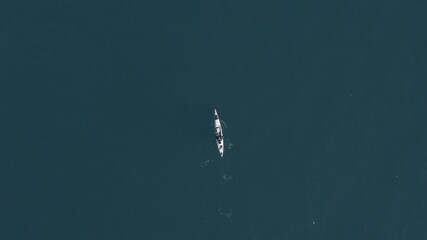 Wall Mural - Single seat fishing canoe rowing at calm open sea water, Aerial view.