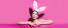 Easter Banner With Bunny Woman. Easter Young Woman Studio Wearing Bunny Ears. Curious Isolated On Pink.