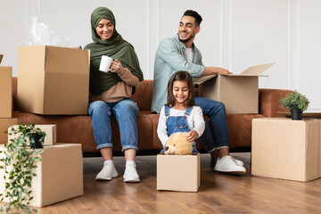 Poster - Happy man, woman and girl packing or unpacking carton boxes