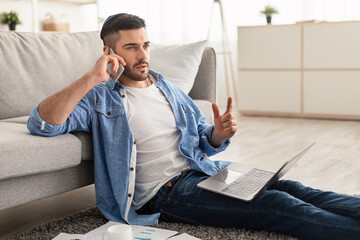 Wall Mural - Portrait of israeli man talking on phone using pc