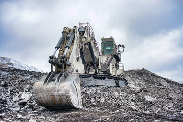 Wall Mural - Big excavator in coal mine at cloudy day, low angle view