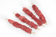 © Marc Calleja - Four veal and beef skewers on a white background