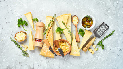 Cheese banner. Set of pieces of hard cheese. Top view. On a gray stone background.