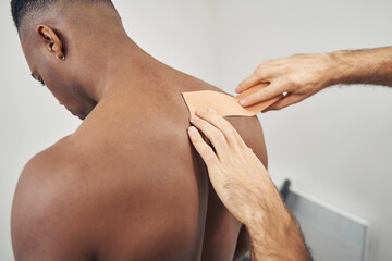 Wall Mural - Physiatrist using kinesiology taping for neck pain relief