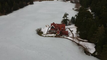 Wall Mural - Bolu Golcuk National Park, lake wooden house on a snowy winter day in the forest in Turkey. Aerial drone view