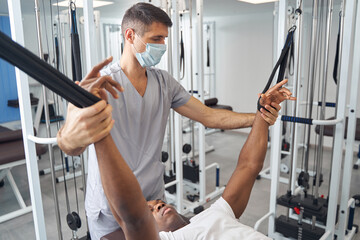 Wall Mural - Rehabilitation physician working with patient at gym