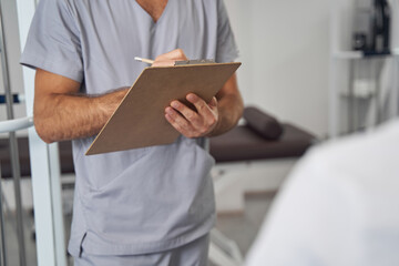 Wall Mural - Doctor standing before his patient during medical consultation