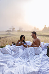 Poster - couple man and women in bed looking out over the rice paddies field in Northern Thailand Nan. foggy mist morning in Nan Thailand outdoor