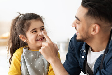 Wall Mural - Baking Fun. Little Girl And Her Arab Dad Fooling Together In Kitchen