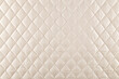 smooth surface of quilted jacket fabric of cream color, background, texture