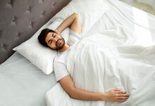 Arab Guy Sleeping Resting Peacefully In His Comfortable Bed At Home, Lying With Closed Eyes, Above View
