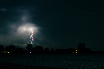 Wall Mural - lightning strikes down from a distant storm cloud