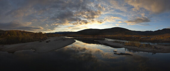 Sticker - Russia. Far East, Magadan region. Evening panorama with a sunset cloudy sky reflected in the water of a tributary of the Kolyma River.