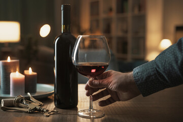 Wall Mural - Man drinking a glass of red wine at home