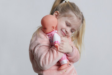 Cute little girl playing with her baby doll