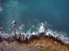 Aerial Top View Of Sea Waves Hitting Rocks.
