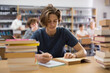 © JackF - Smart teenager boy spending time in library and doing homework.