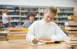 © JackF - Intelligent female teenager engaged in research working with books in library