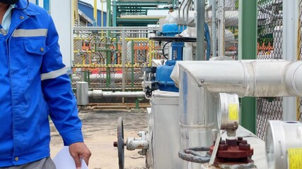 Wall Mural - Petroleum refinery production technicians inspect pressure gauge mounted on hot water supply lines, safety working concepts and industrial technology.