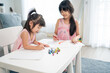 © Kawee - Asian young girl children drawing and coloring paper in living room.
