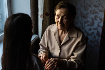 Wall Mural - Little baby girl and very old woman. Little child hugging grandmother. Granddaughter