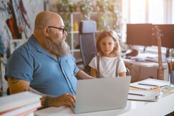 Poster - Bearded father looks at little girl taking part in video lesson via laptop at home