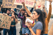 People Strike Against Climate Change And Pollution, Portrait Of Young Woman Holding A Megaphone And Raise Arm, Green New Deal Protest, Warm Filter