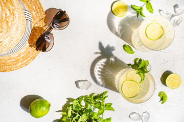 Wall Mural - Tradition Summer drink cocktail mojito with ice, lime and mint on white with natural light and bright shadows. Top view