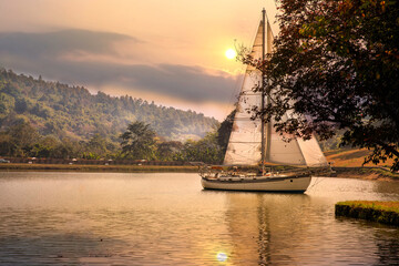 Yacht sailing against sunset. Holiday lifestyle landscape with skyline sailboat and sunset silhouette. Yachting tourism - maritime evening walk. travel concept