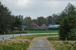 farmhouse and barns near asphalt road and biking road in autumn