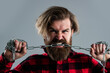 Brutal bearded man biting steel chain with strong teeth, correction of bite