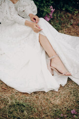 Wall Mural - Young blonde girl in a white wedding dress with an open top near a lilac