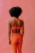 © Carlos David - back shot of young fit woman in sports outfit posing isolated on pink background