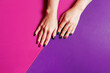 © Anastasia Studio - Style festive manicure on a purple background with a place for text. Women's hands with colored pink nail. Stylish beauty concept for your advertising