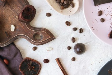 Wall Mural - Black and milk chocolate, sweets, dried citrus fruits, coffee beans and spices on the table, top view, home cooking, sweet food