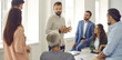 © Studio Romantic - Group of people having a work meeting. Serious young male team leader, corporate manager, businessman or business coach standing in office and talking to group of employees. Website banner background