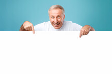 Mature Man Peeking Out Blank White Advertising Billboard At Studio