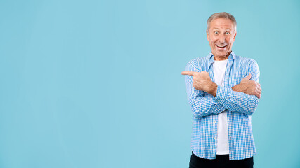 Excited mature man pointing aside at copy space